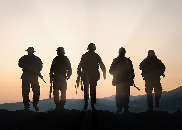 group of soldiers standing at sunset